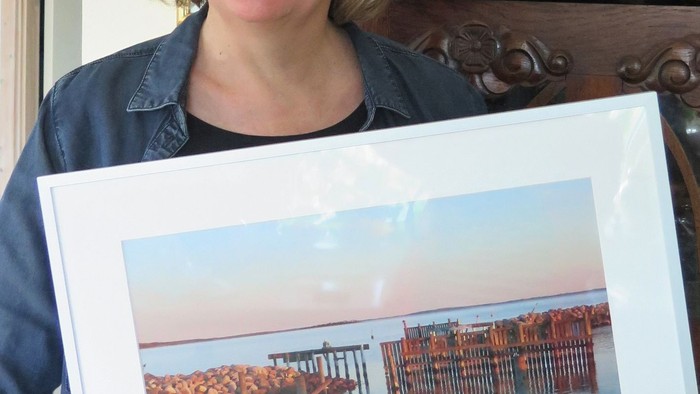 Kvinde holder et billede af en bro over vand