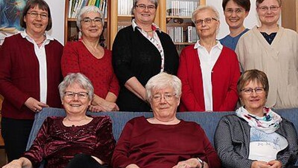 Ein Gruppe von neun älteren Frauen posiert für ein Gruppenfoto