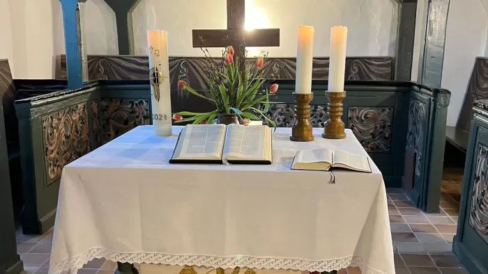 Altar mit Kreuz, Kerzen und religiösen Texten in einer Kirche