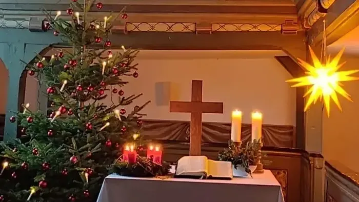 Kirchenaltar mit Weihnachtsbaum, Kerzen und Kreuz