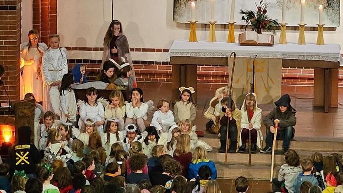 Gottesdienst in einer Kirche mit vielen Gläubigen und einem großen Kreuz.