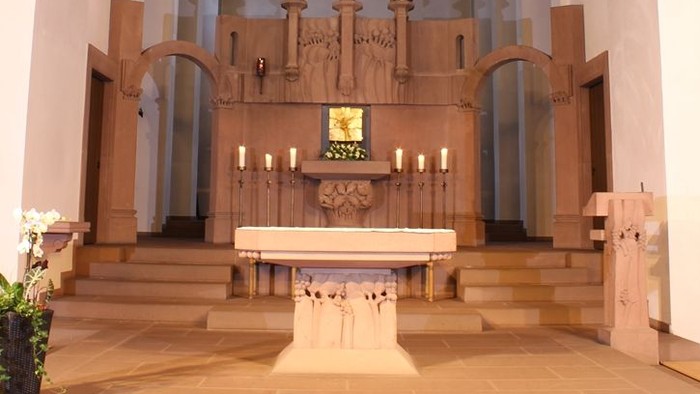 Die Kirche mit Altar, Kreuz und farbigem Fenster