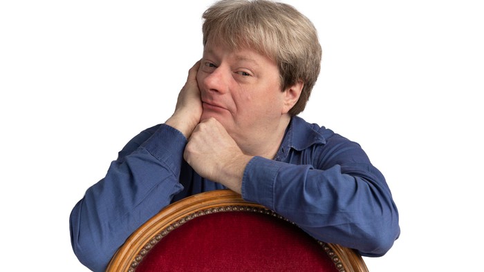 Mann sitzt nachdenklich in einem Stuhl.