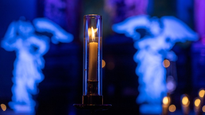 En lysende lykt står i fokus, omgivet af blå og violette farver.