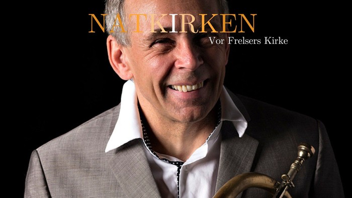 Mand der smiler, mens han holder en trompet