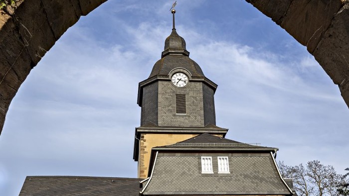 Steinkirche mit Uhrturm und bogigem Eingang