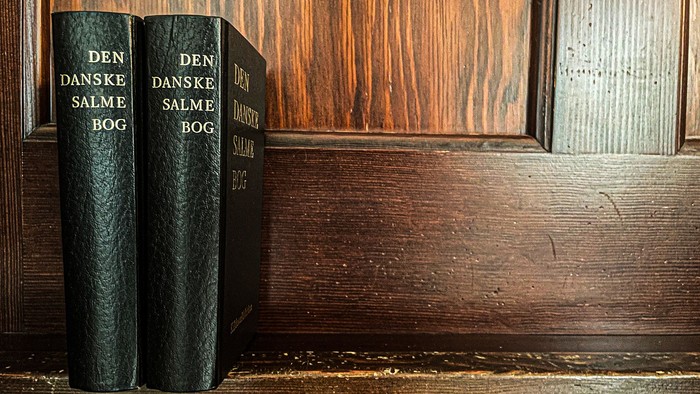 To boger er placeret på en træhylde.