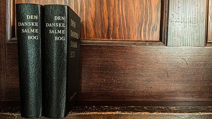 To boger er placeret på en træhylde.