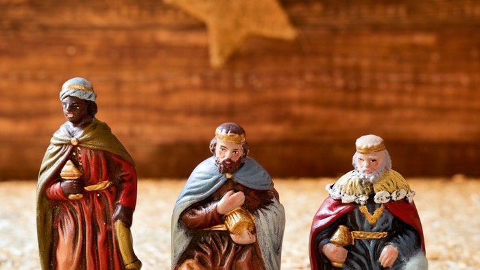 Keramiske krybbefigurer af De Tre Vise Mænd, der knæler med en stjerneformet baggrund.