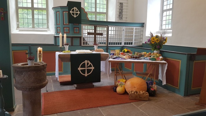 Kirchenaltar mit Kreuz, Kerzen und Herbstdekorationen