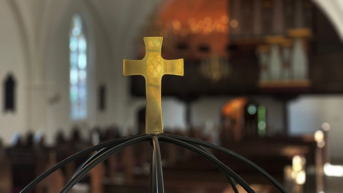 Guld kors på globus i kirke.