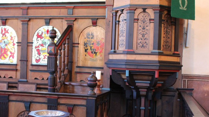 Kircheninneres mit hölzerner Kanzel und Buntglasfenstern