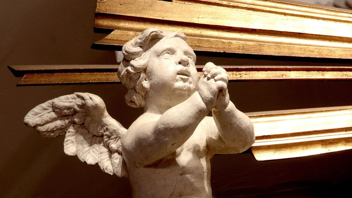 En lille engelstatue med vinger og horn.