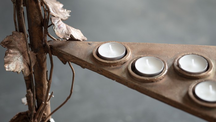 En række lyse lys på en træstok med tørre blader ved siden af