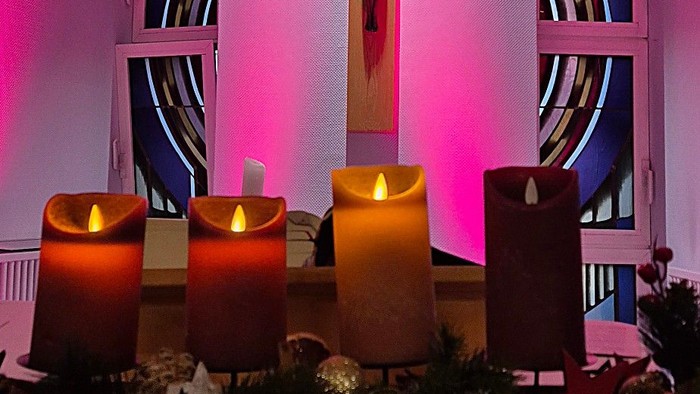 Buntes Kirchenfenster mit Kreuz und Kerzen