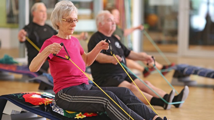 Senioren machen Fitnessübungen mit elastischen Bändern
