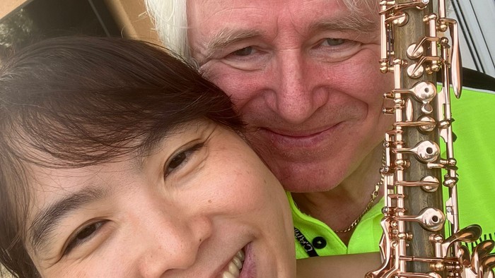Ein Mann mit Saxophon posiert mit einer Frau.
