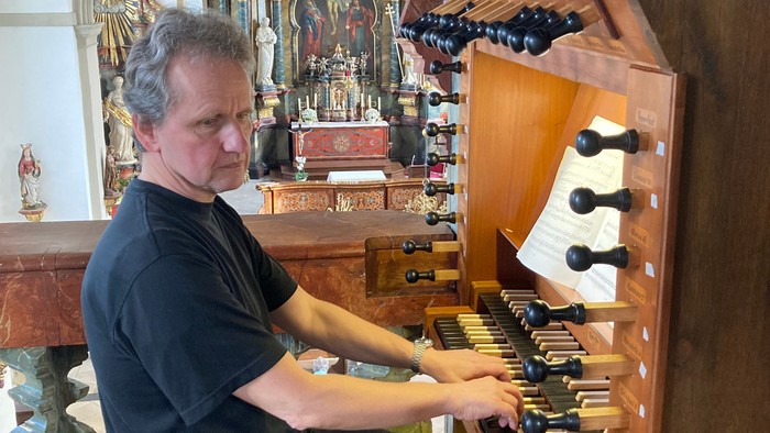 Mann spielt Orgel in Kirche