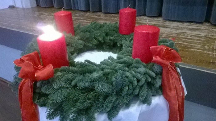 Ein Adventskranz mit vier roten Kerzen auf einem Tisch