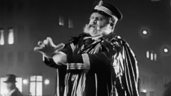 Ein Mann in Kapuze hält ein Baby im Mondlicht.