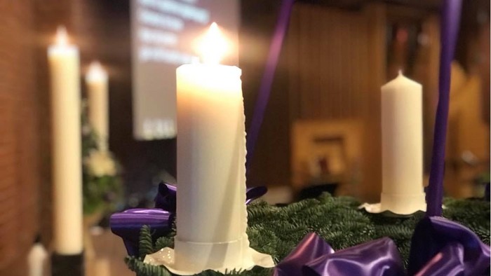 Firelyse på adventskranse med grønne blomster og紫støv.