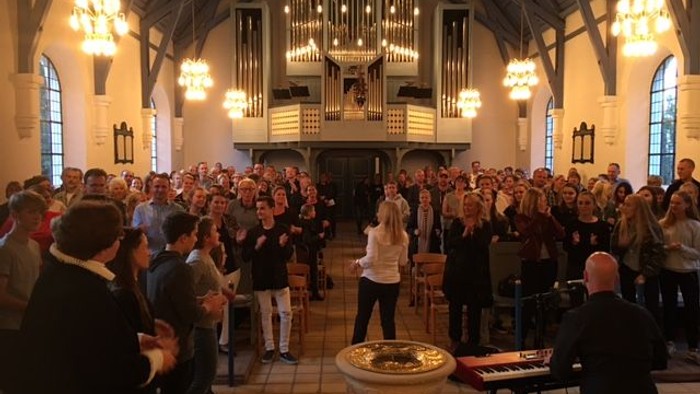 En stor kirke med mange mennesker, der deltager i en ceremoni.