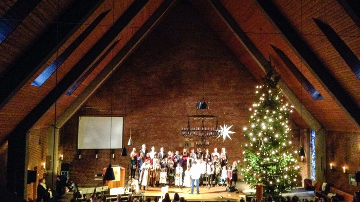 Kirchenchor tritt vor einem Weihnachtsbaum auf