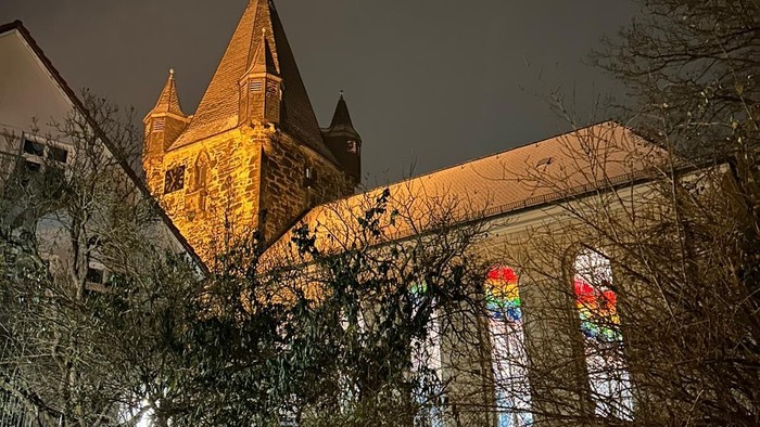 Kirche, die nachts mit bunten Buntglasfenstern beleuchtet ist.