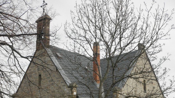 Altes steinernes Kirchgebäude mit spitzem Dach und zwei Fenstern.
