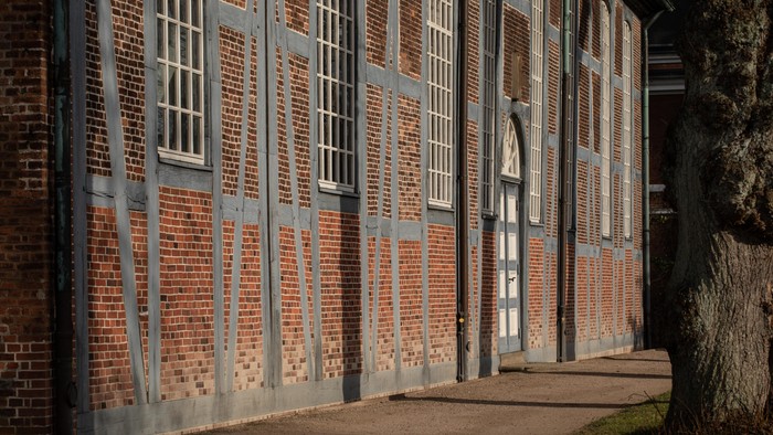 Alte Backsteingebäude mit hohen Fenstern und Metallgittern