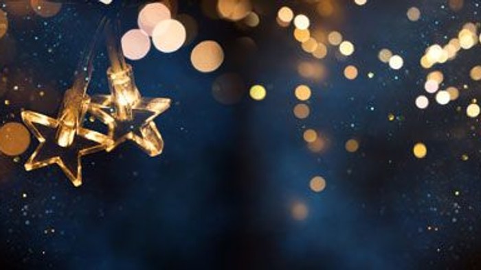 Goldener Stern vor dunklem, glitzerndem Hintergrund