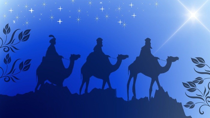 Tre vise mænd på kameler mod en stjernefuld nat