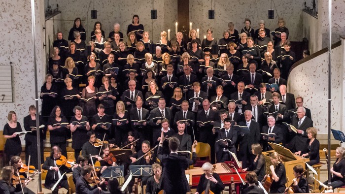 Ein großer Chor und Orchester proben in einem Konzertsaal