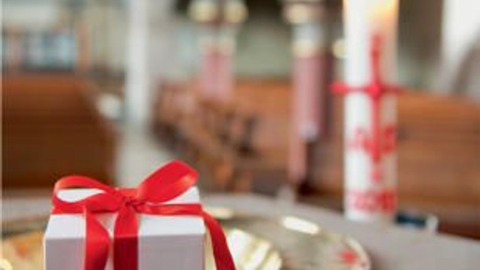 Weihnachtsgeschenk mit roter Schleife und Kerze