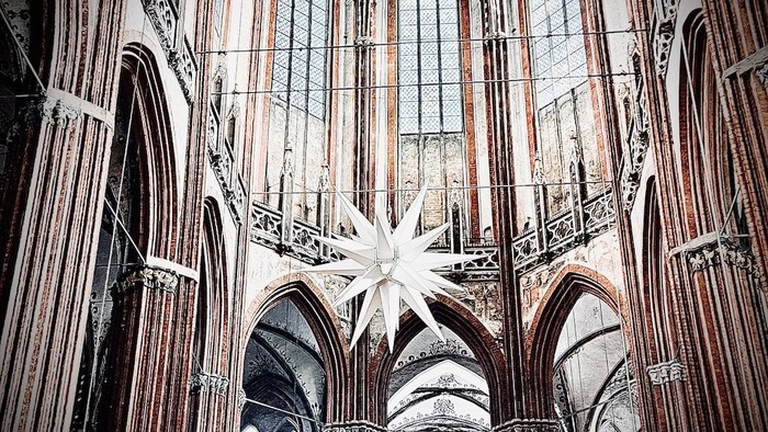Innenraum einer gotischen Kathedrale mit hohem Gewölbe und Sterndekoration