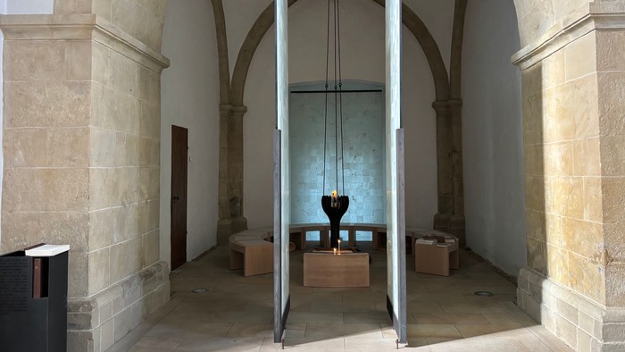 Auf dem Bild ist der Raum der Stille der Christuskirche zu sehen. In der Mitte ist eine Kerze