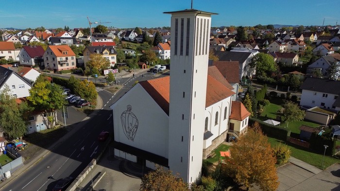 Weiße Kirche mit hohem Turm in Wohngebiet