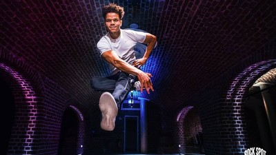 Junger Mann springt auf Bühne, bunte Lichter, "ROCK SPOT" im Hintergrund