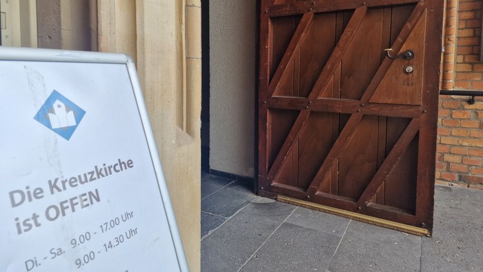 Die Kreuzkirche ist geöffnet, Holztür mit zwei Flügeln
