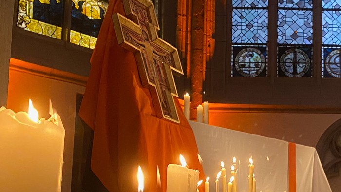 Kirchliche Innenansicht mit brennenden Kerzen und Kreuz