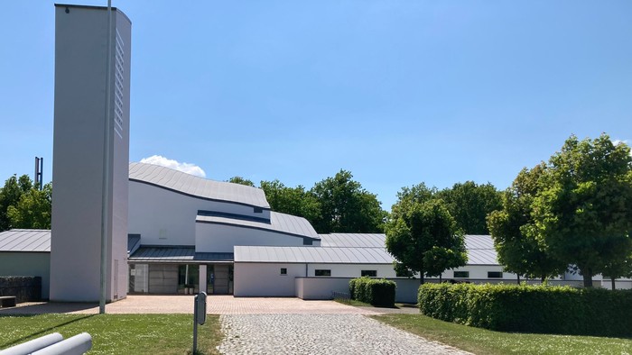 En moderne bygning med fladt tag og stenvej til indfald.