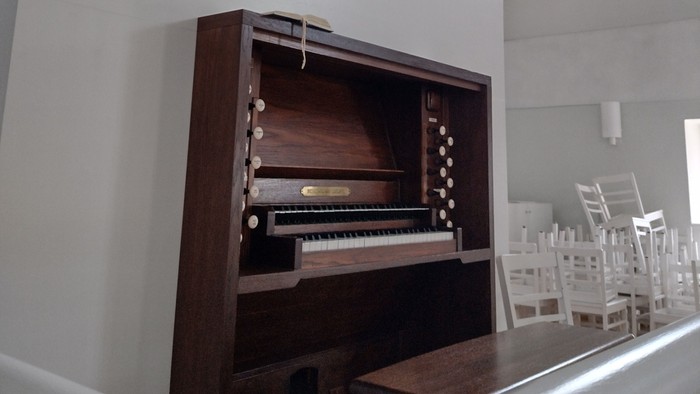 Große Orgel in einem Kirchenraum mit weißen Stühlen