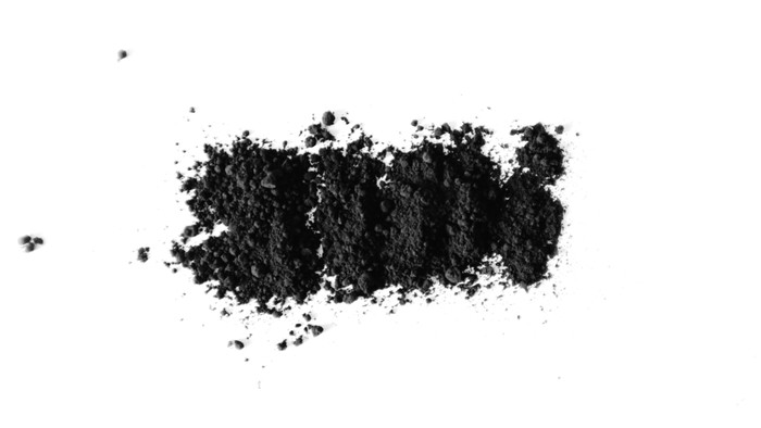 Small pile of black powder on white surface.