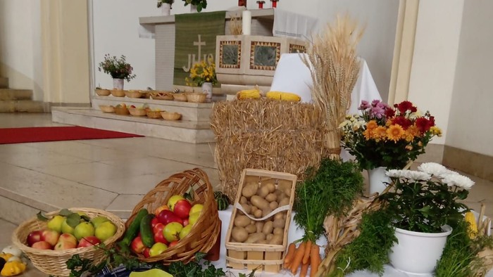 Auf dem Altar stehen Obst, Gemüse und Blumen, ein Korb und ein Kreuz im Hintergrund
