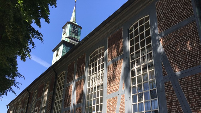 Altes Backsteingebäude mit hohem Turm und großen Fenstern