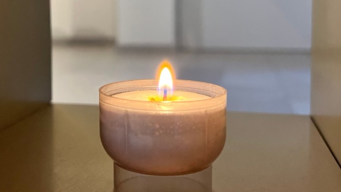 Kleine Kerze auf Tisch in hellem Raum