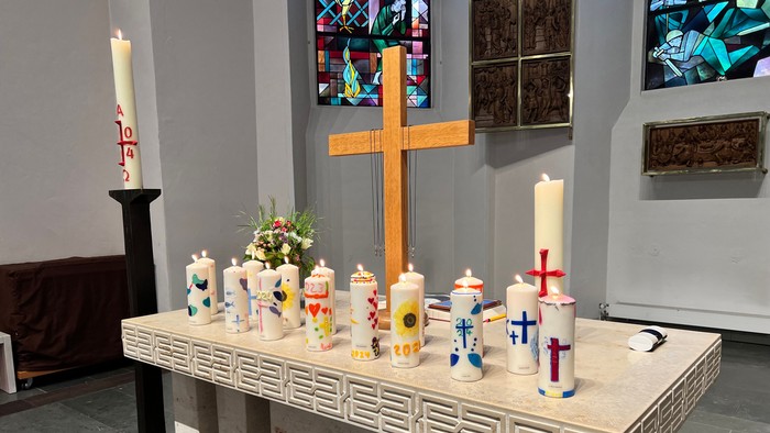 Ein Tisch mit Kerzen und Kreuz in einer Kirche