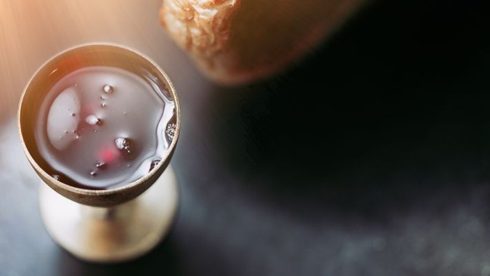 A glass of dark liquid with ice cubes.
