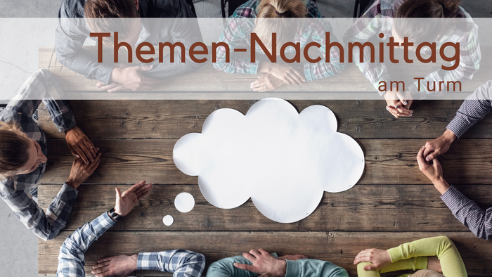 Menschen um einen Tisch von oben fotografiert. In der Mitte eine weiße Gedankenblase