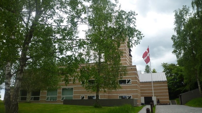 Et moderne bygning med en rød flag på en grøn plads